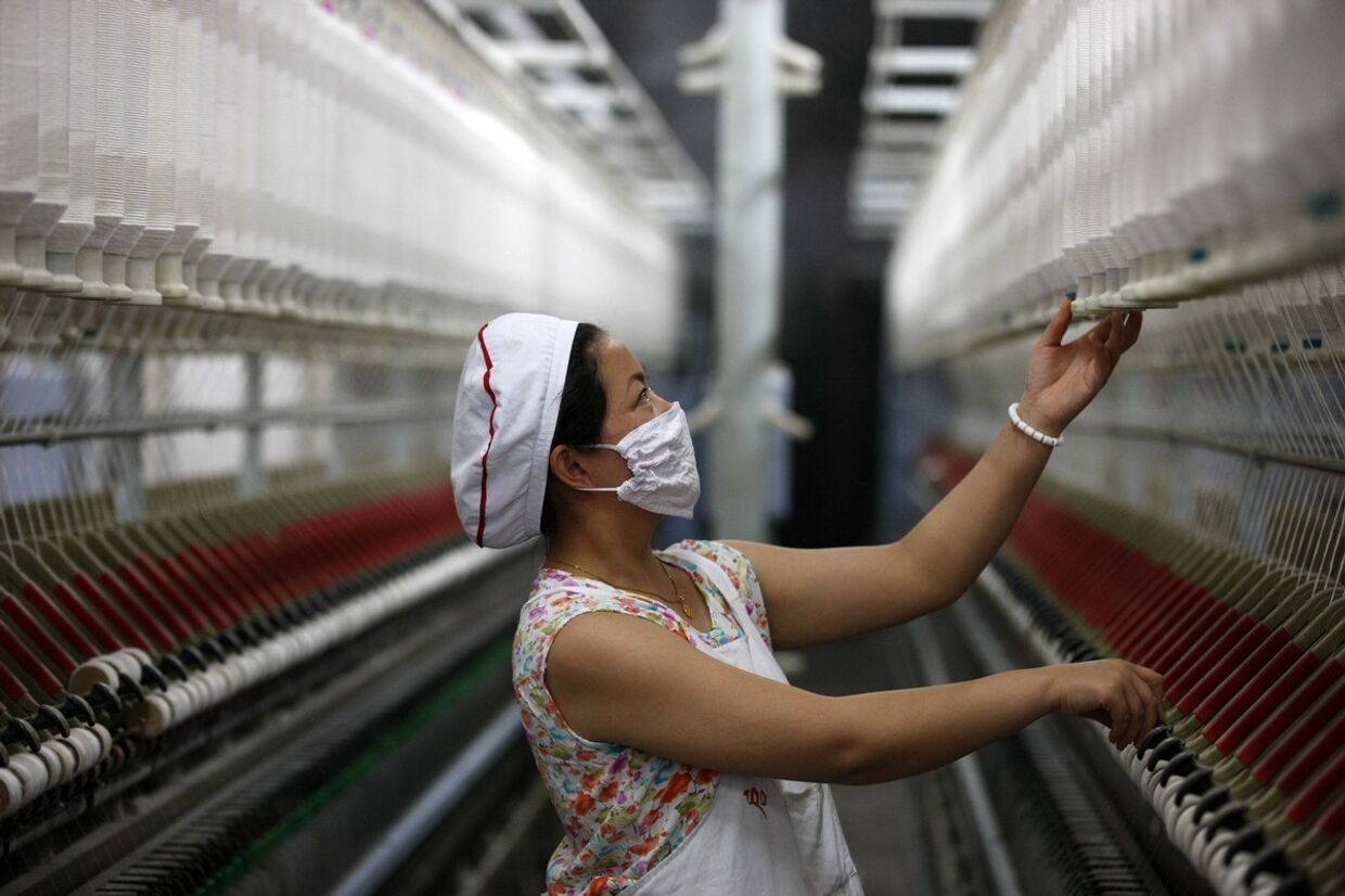 Женщина работает на текстильной фабрике в Китае