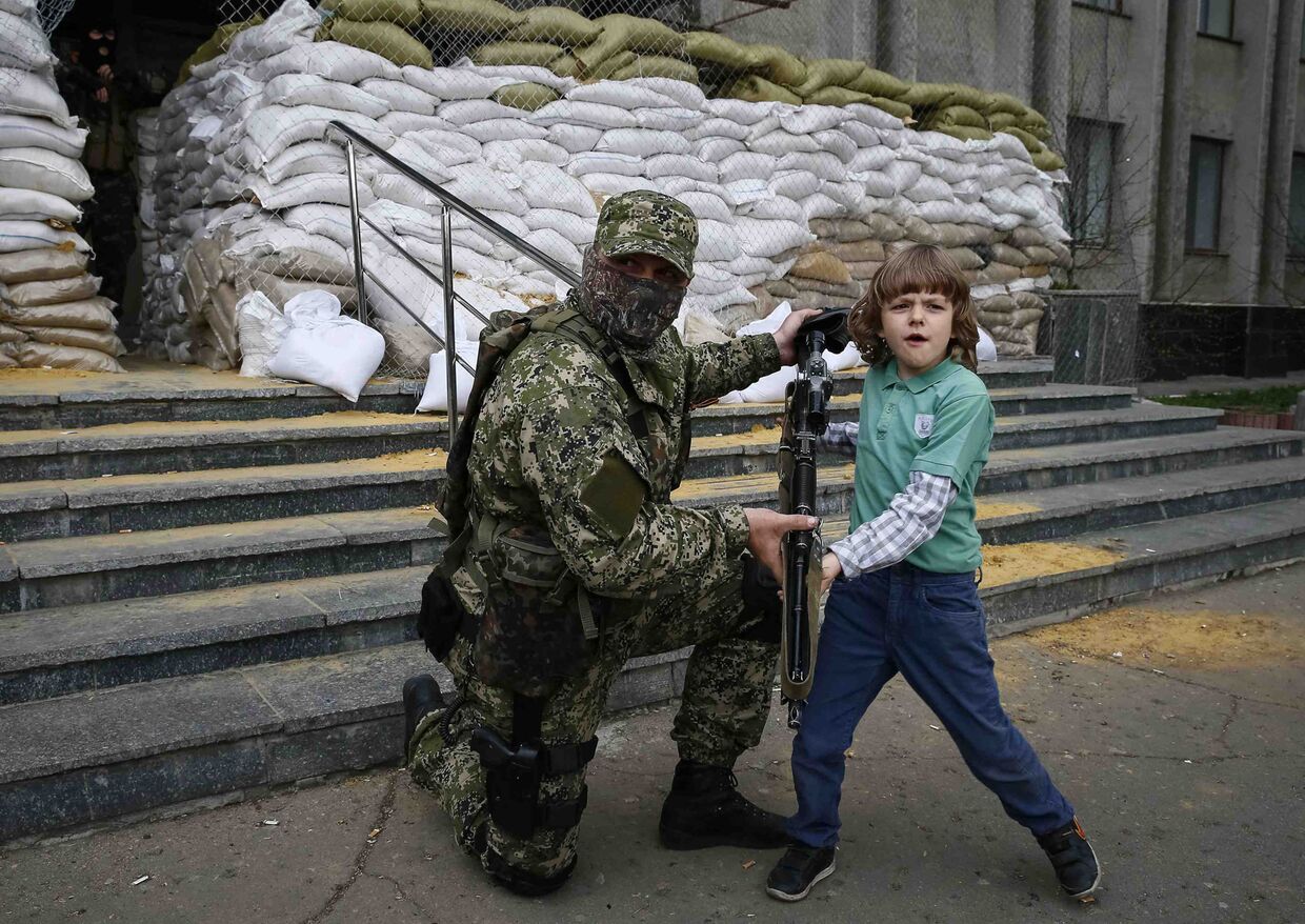 Пророссийский активист фотографируется с местным мальчиком в Славянске