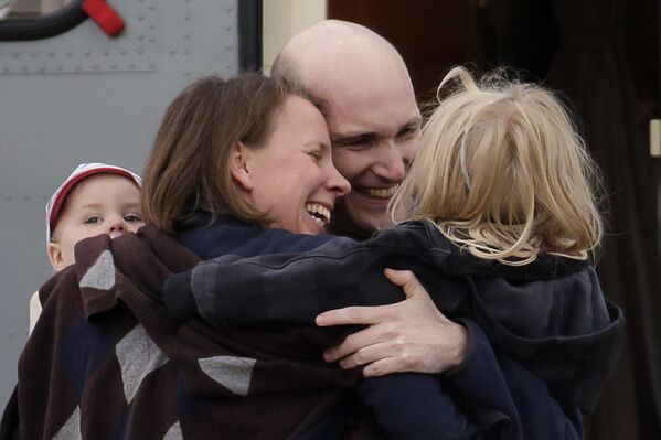 Французский журналист Николя Энен обнимается с семьей после возвращения из сирийского плена