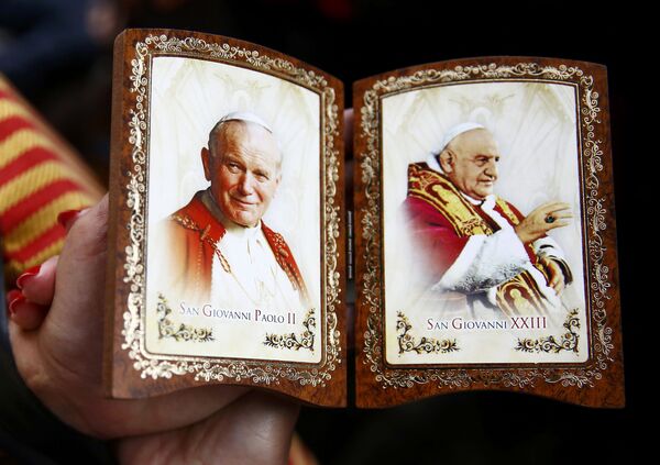 Сувенир с изображениями канонизируемых Иоанна XXIII и Иоанна Павла II в руках у паломника из Польши