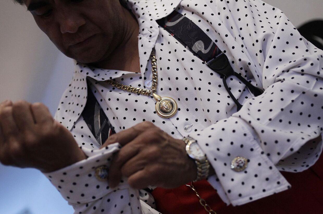 Хосе де Хесус Гонсалес де ля Роса надевает запонки, готовясь к выходу в своем костюме в стиле пачуко