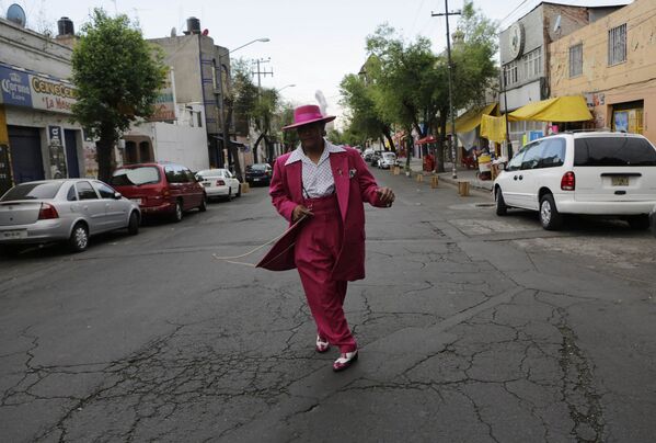 Человек, одетый в стиле пачуко, идет по улице Мехико