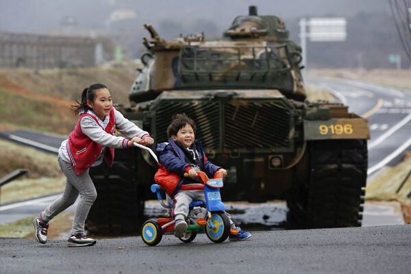Дети играют на фоне танка на острове Пэннёндо