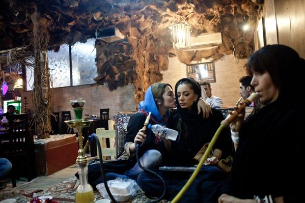 Молодые женщины курят кальян в кафе в Тегеране