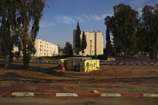 Раскрашенное бомбоубежище рядом с домами из укрепленного бетона в городе Сдерот в Израиле 