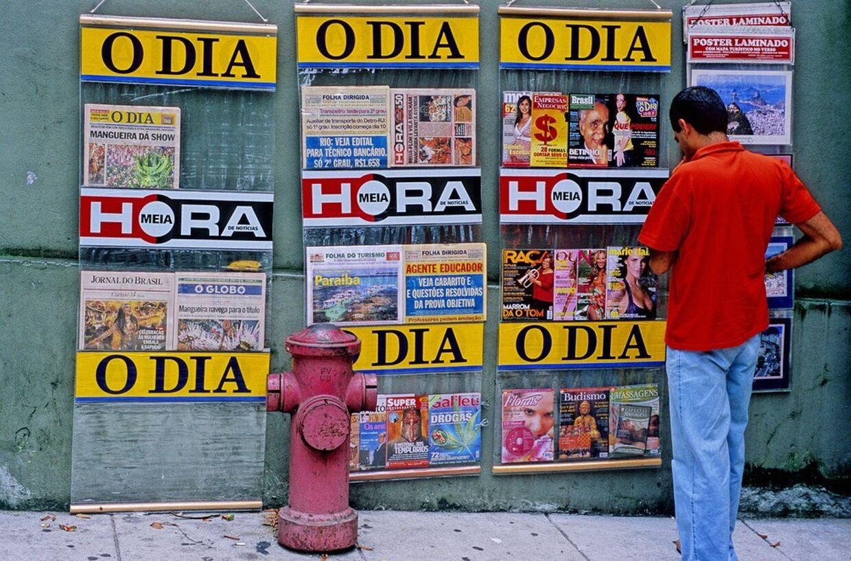 Мужчина смотрит на обложки журналов на улице Рио-де-Жанейро