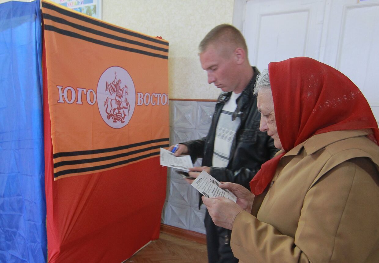 Местные жители изучают бюллетени для голосования на референдуме о статусе Луганской области на избирательном участке в селе Самсоновка под Луганском.
