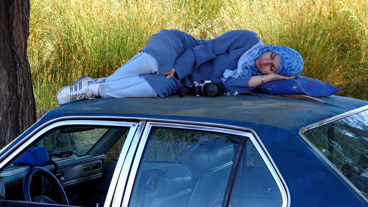 Иранская девушка спит на крыше машины