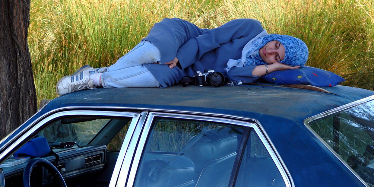Иранская девушка спит на крыше машины