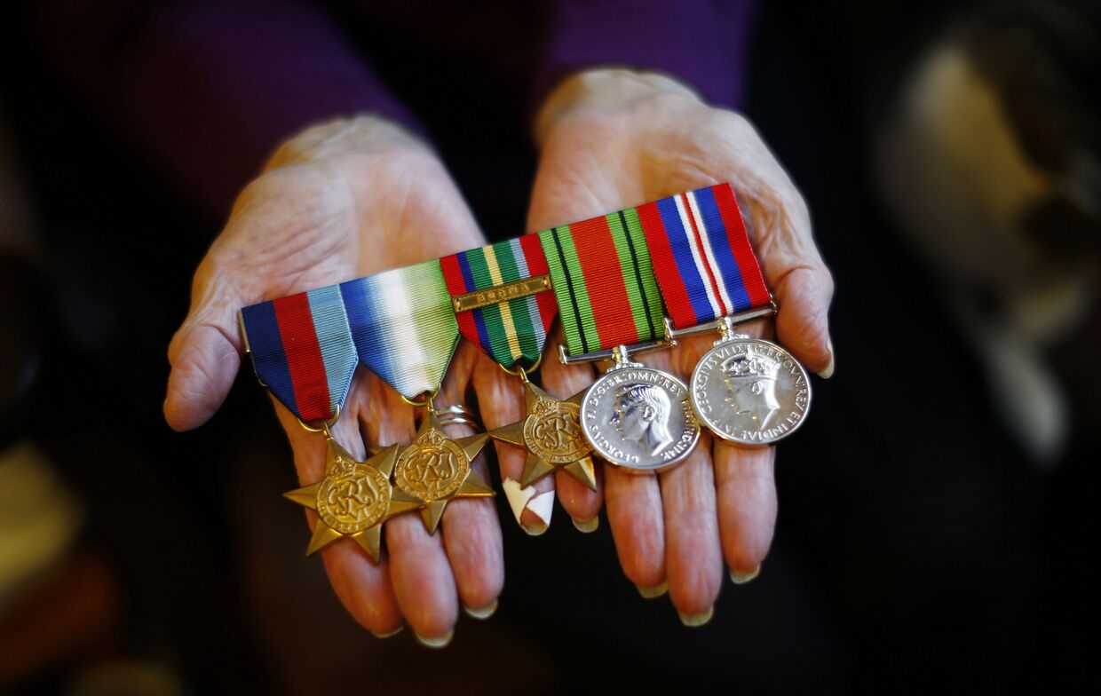 Мэри Барбер показывает медали своего мужа, ветерана Второй мировой войны