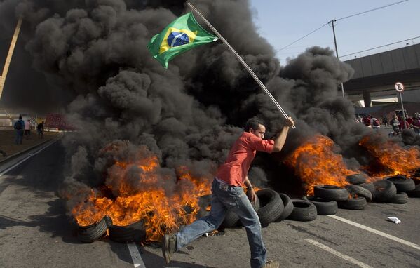 Участник Движения бездомных рабочих Бразилии во время акции протеста против затрат на проведение Чемпионата мира по футболу 