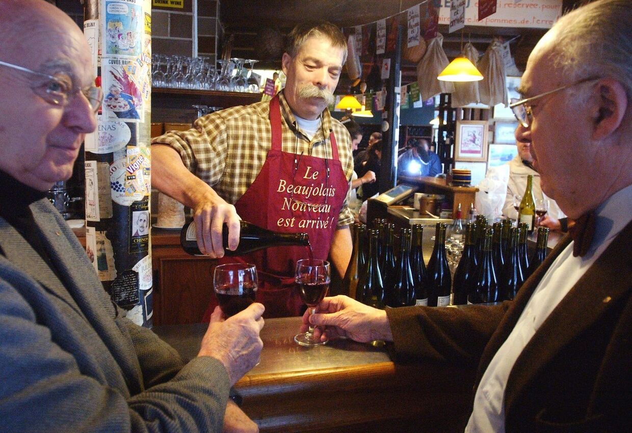 Люди пьют вино в ресторане в Париже