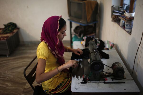 Девочка шьет у себя дома в мусульманском квартале Ахмадабада