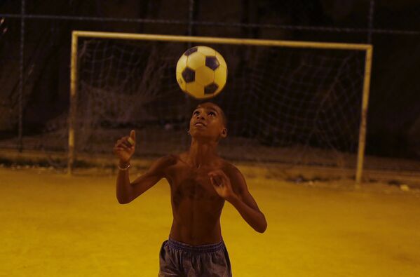 Мальчик играет в футбол в трущобах Сао-Карлос в Рио-де-Жанейро