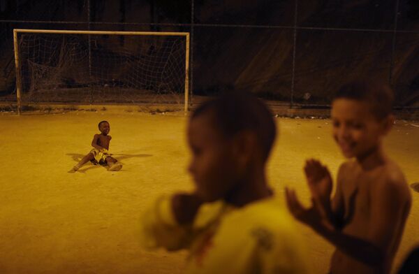 Дети отдыхают после футбольного матча в трущобе Сао-Карлос в Рио-де-Жанейро