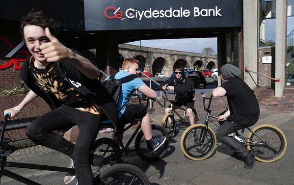 Школьники катаются на велосипедах после занятий в городе Килмарнок в Шотландии