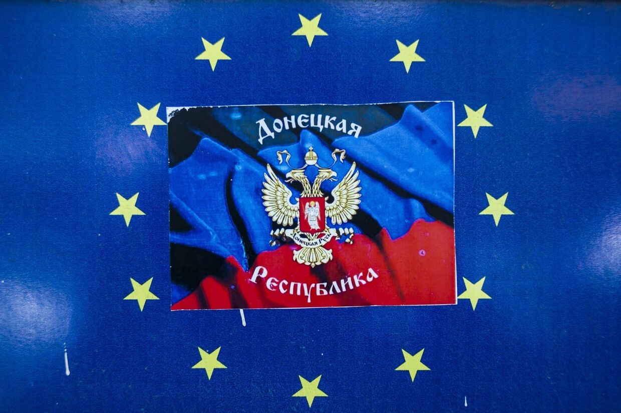 Наклейка с символом Донецкой республики поверх эмблемы Евросоюза в окне магазина в Донецке