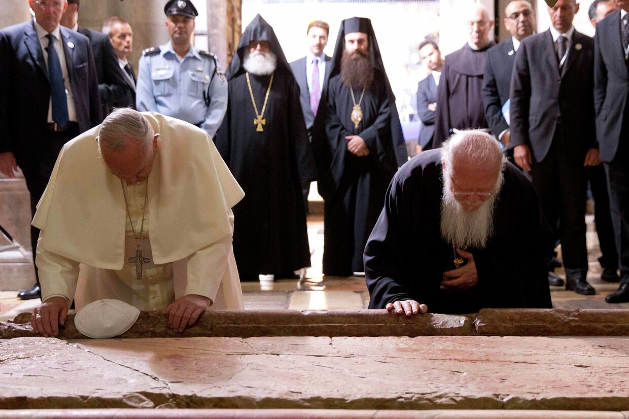 Папа Римский Франциск и Патриарх Константинопольский Варфоломей I прикасаются к камню помазания в Иерусалиме