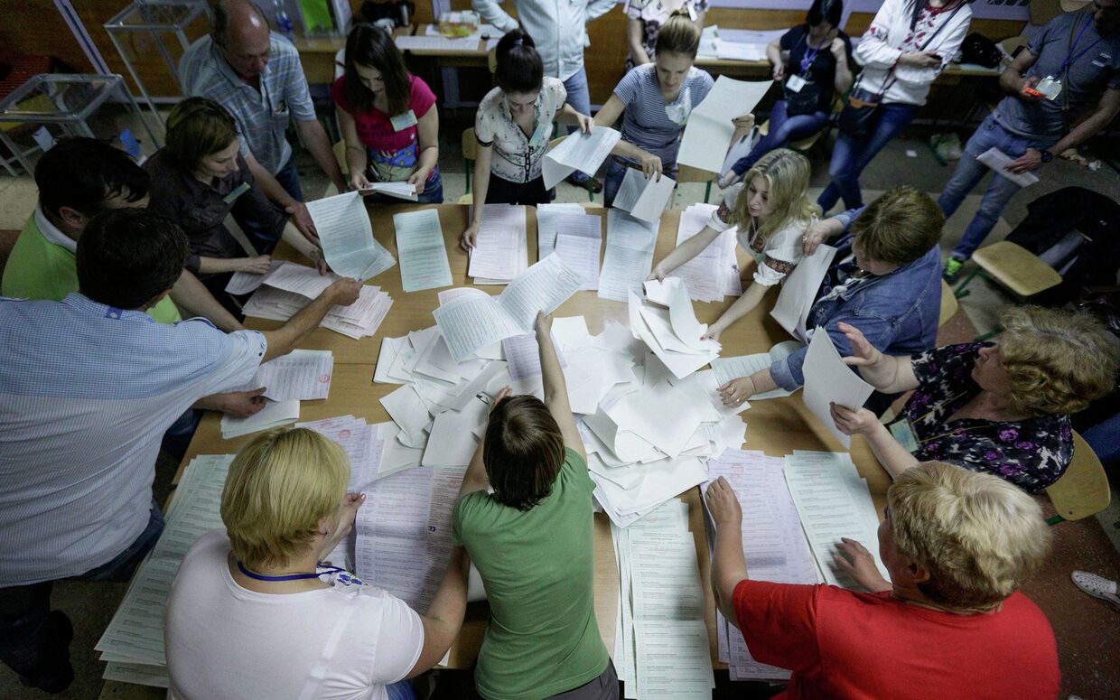 Члены избирательной комиссии во время подсчета голосов на одном из избирательных участков в Киеве