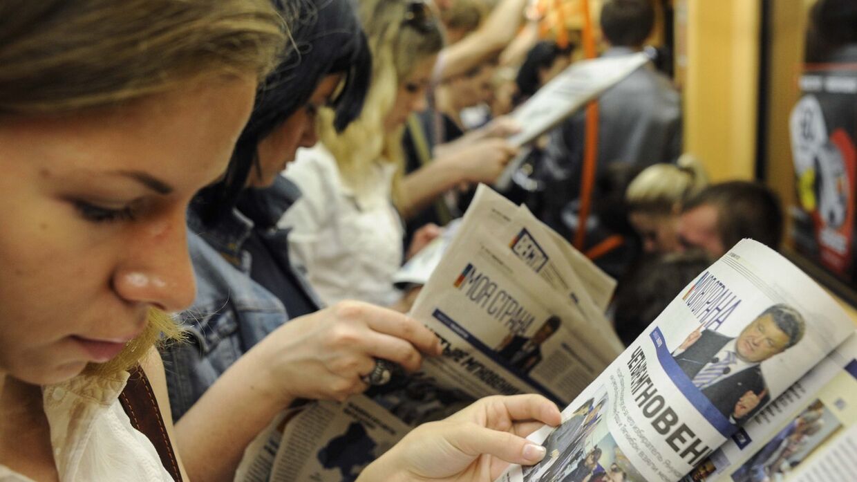 Киевляне читают газеты в метро