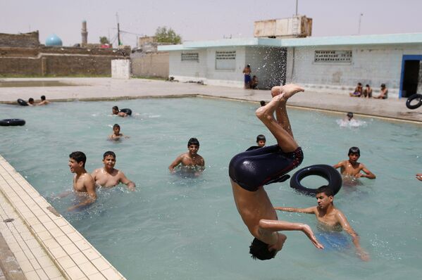 Подростки купаются в бассейне в пригороде Багдада Мадинат-эс-Садр