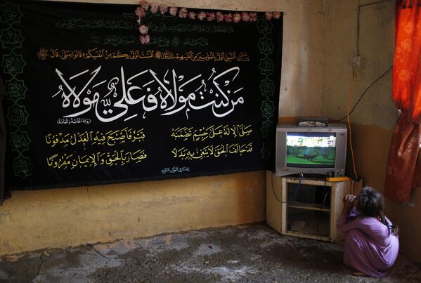 Девочка смотрит телевизор в своем доме в восточном Багдаде