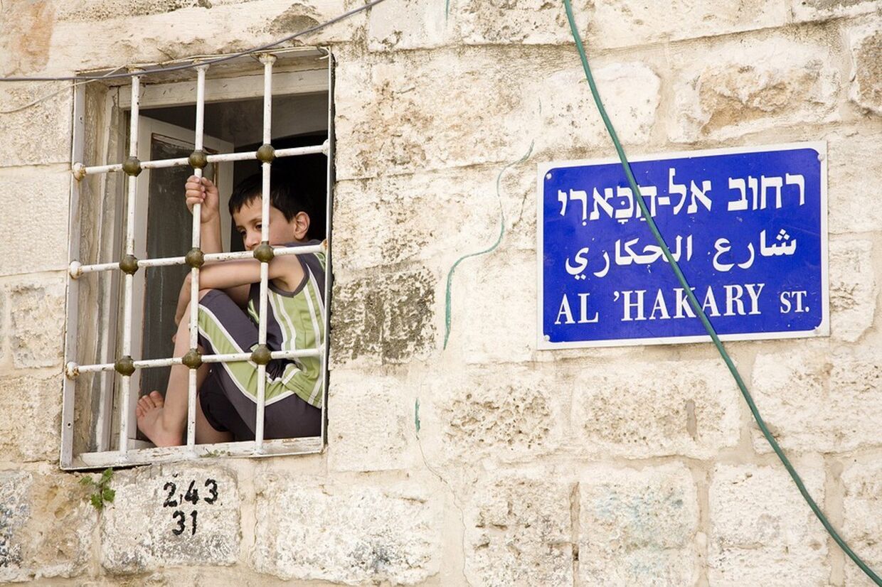 Мальчик смотрит из окна в Иерусалиме