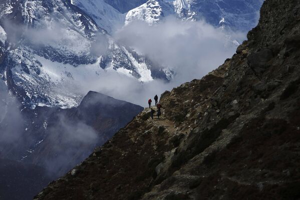 Альпинисты возвращаются из базового лагеря Эвереста в Фериче, сзади – гора Тамсерку