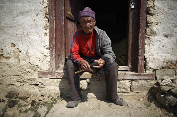 Кхунджунг Шерпа на ступенях своего дома в Намче, район Солукхумбу