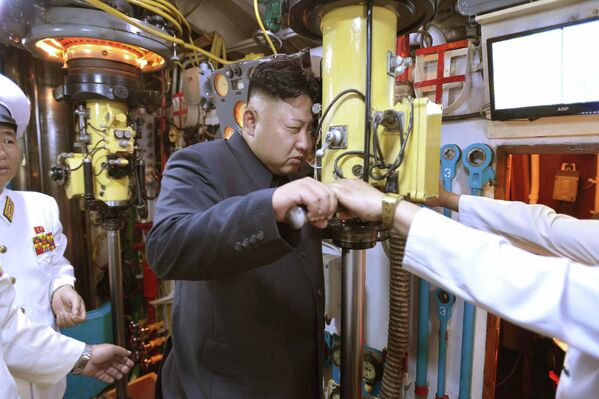 Северокорейский лидер Ким Чен Ын смотрит в перископ подводной лодки во время инспекции вооруженных сил КНДР