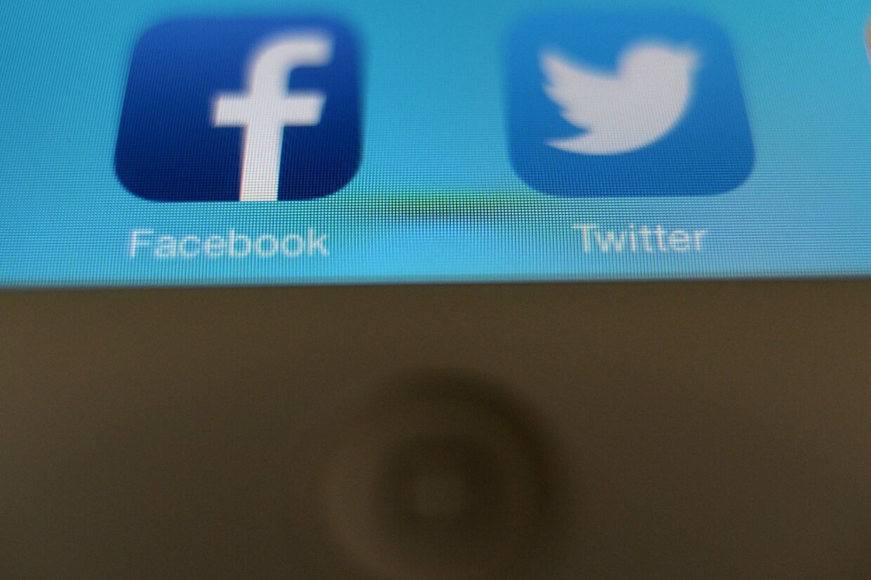 Иконки приложений Facebook и Twitter на экране планшетного компьютера