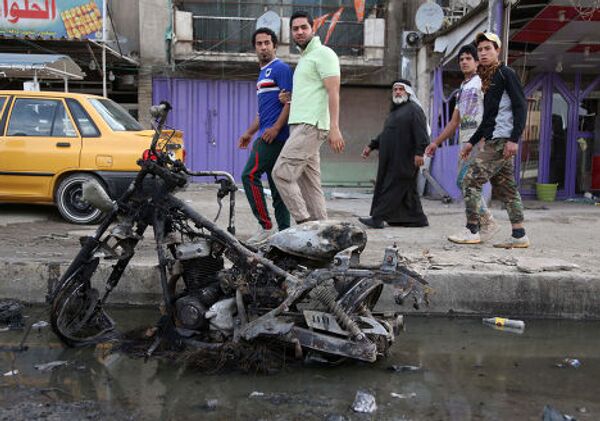 Последствия взрыва заложенной в автомобиле бомбы в Багдаде