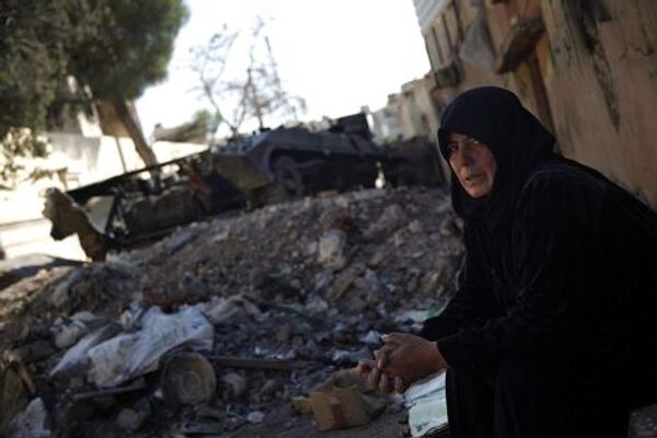 Женщина у разрушенного бронетранспортера на улице Алеппо