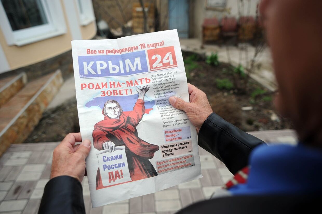 Житель Крыма читает газету, поддерживающую референдум 16 марта 
