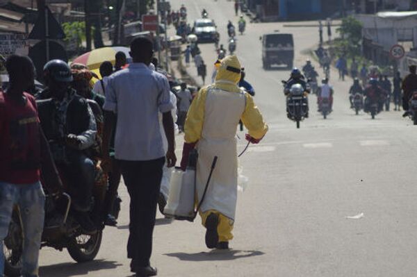 Медицинский работник на улице города Кенема в Сьерра-Леоне