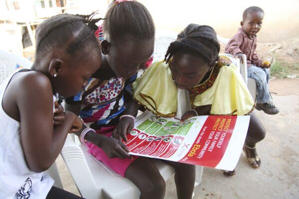 Девочки рассматривают плакат ЮНИСЕФ о профилактике вируса Эбола