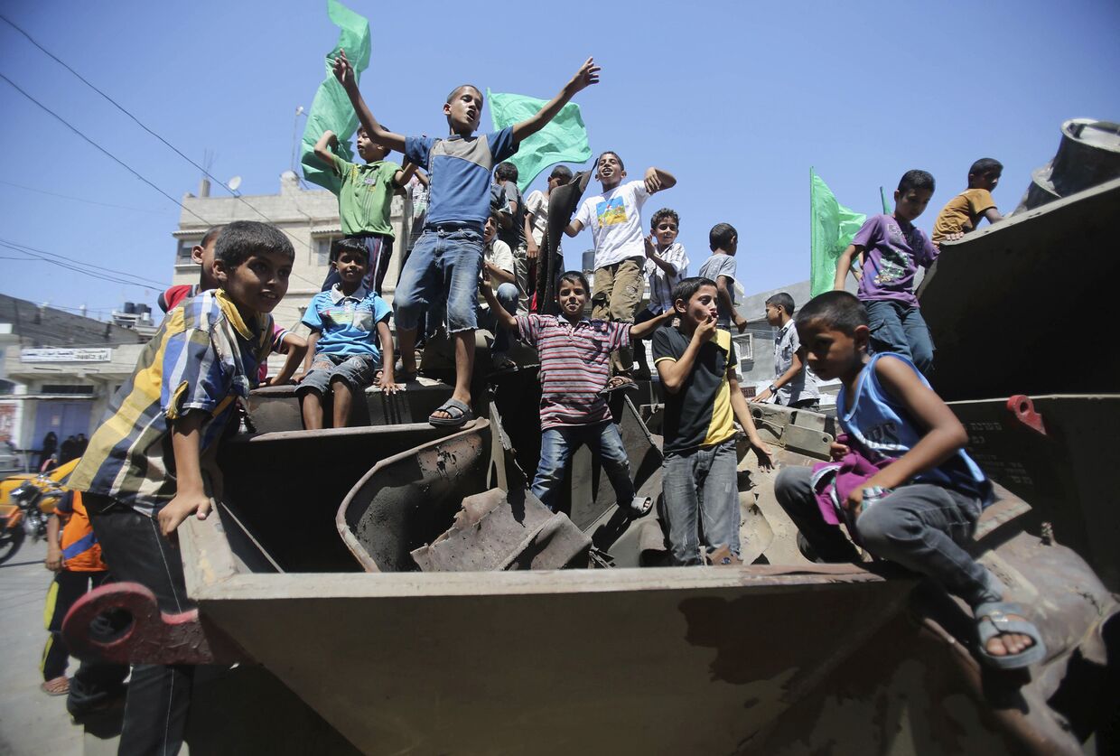 Палестинские дети с флагами ХАМАС на танке, оставленном израильской армией