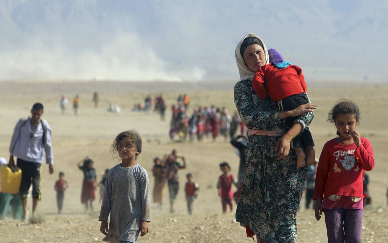 Беженцы-езиды идут в сторону сирийской границы у горы Синджар