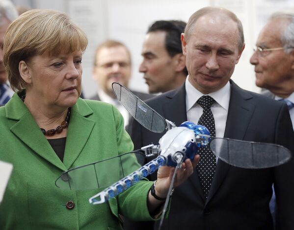 Владимир Путин и Ангела Меркель смотрят на робота BionicOpter
