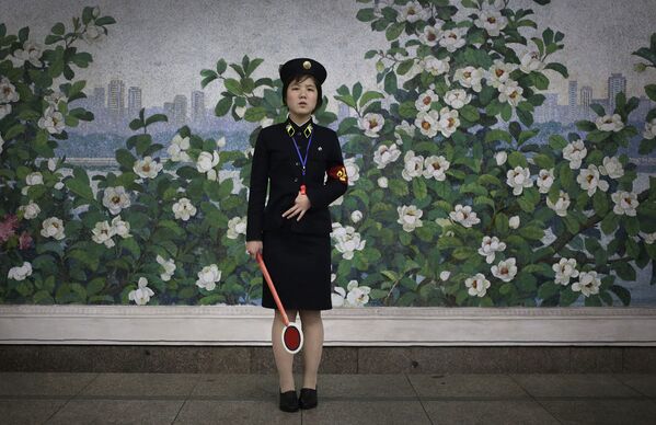 Работница метро в Пхеньяне в ожидании прибытия поезда