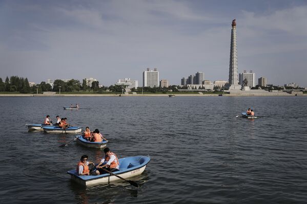 Люди катаются на лодках по реке Тэдонган в Пхеньяне