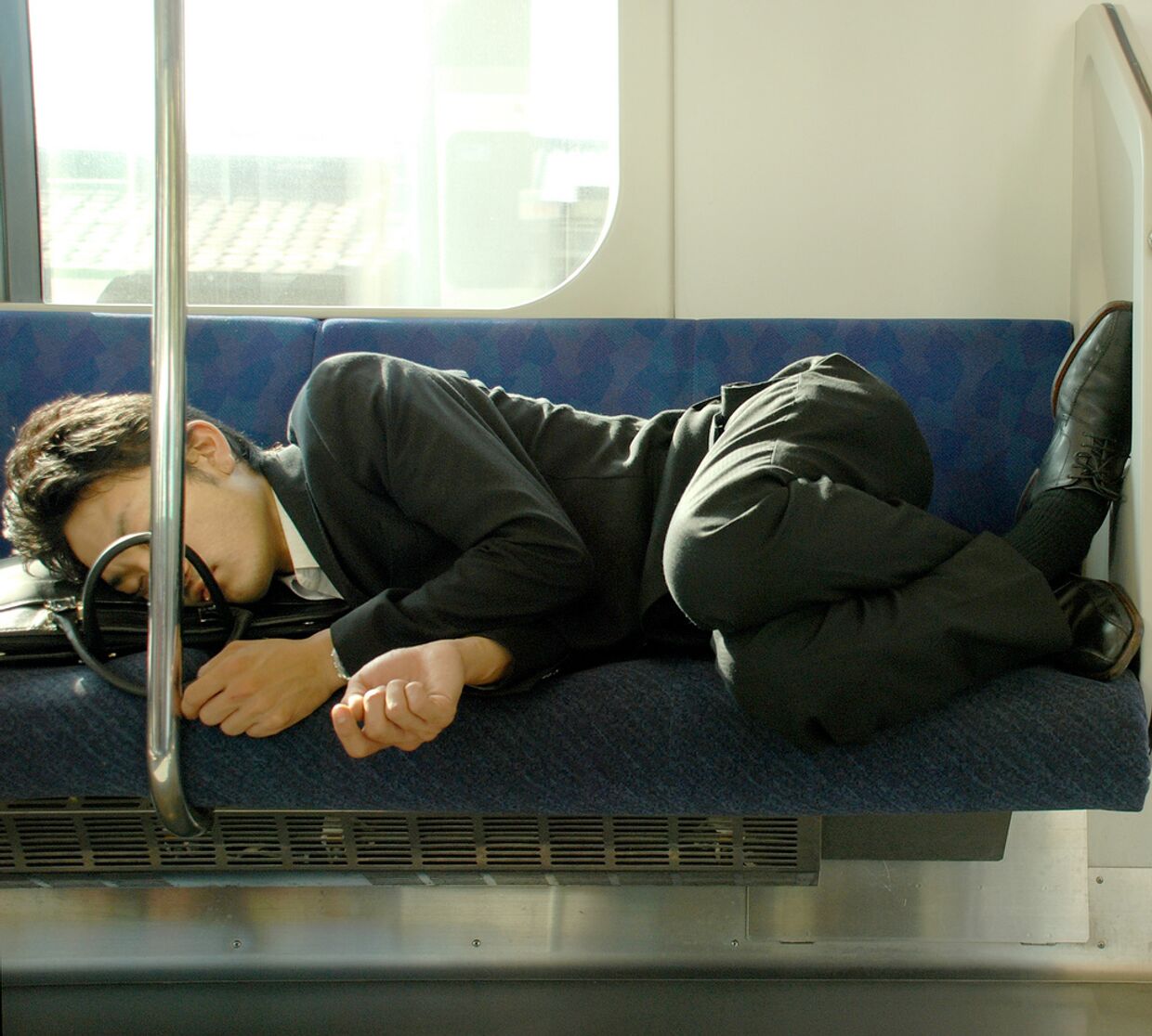 Мужчина спит в вагоне метро Токио