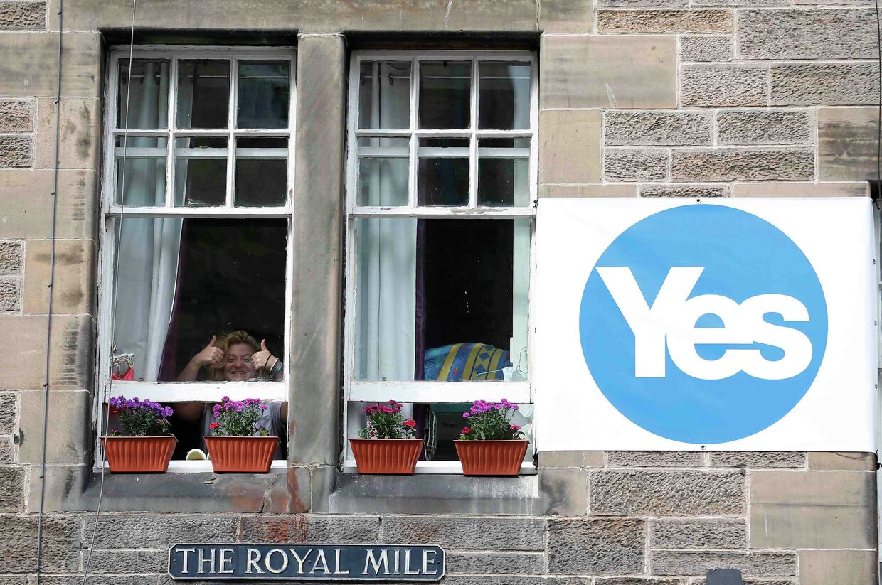 Женщина разместила возле окна плакат в поддержку независимости Шотландии в Эдинбурге