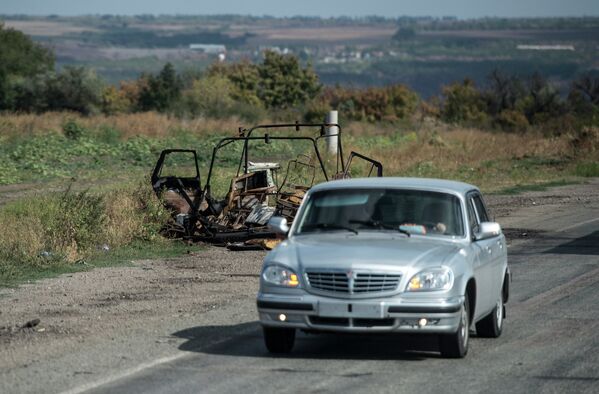 Сгоревшая машина у дороги на окраине Луганска