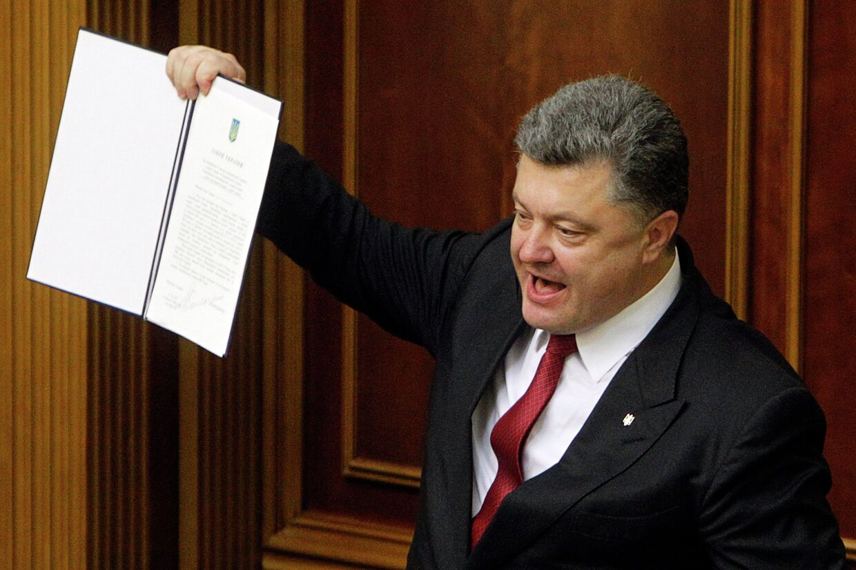 Президент Украины Петр Порошенко показывает подписанное соглашение об ассоциаци с ЕС