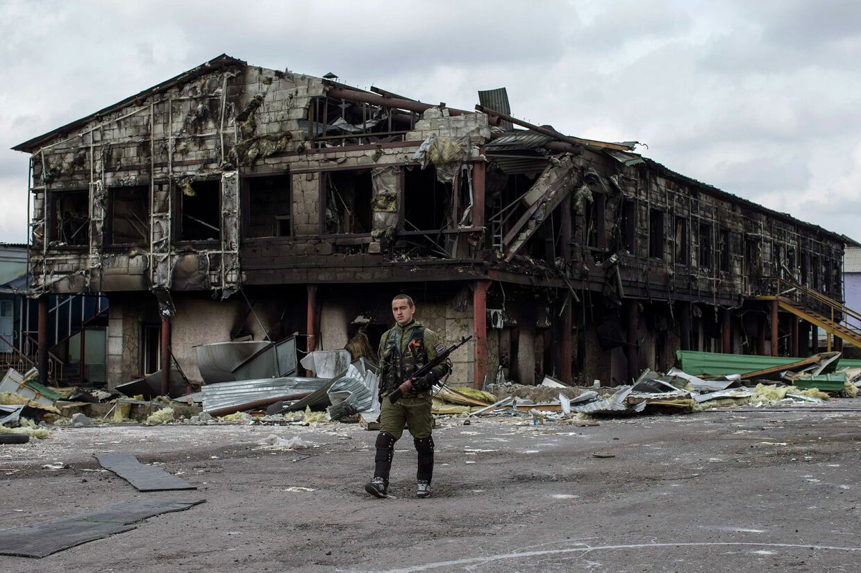 Боец народного ополчения возле разрушенного завода в селе Нижняя Крынка