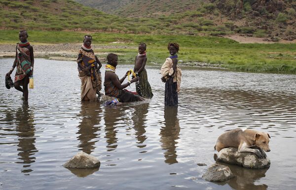 Женщина-туркана с детьми в озере с теплой водой