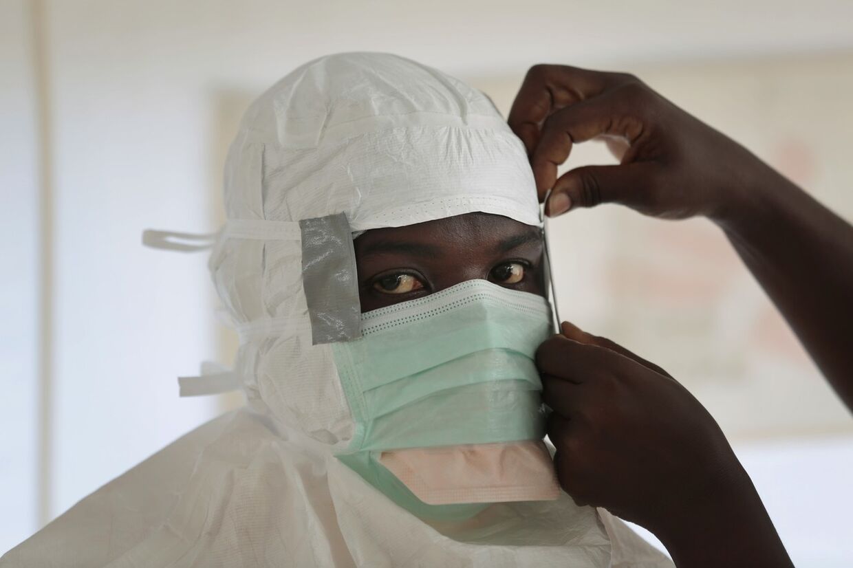 Медсестра из организации «Врачи без границ» готовится к входу в зону высокого риска в Центре по лечению Эболы в Монровии