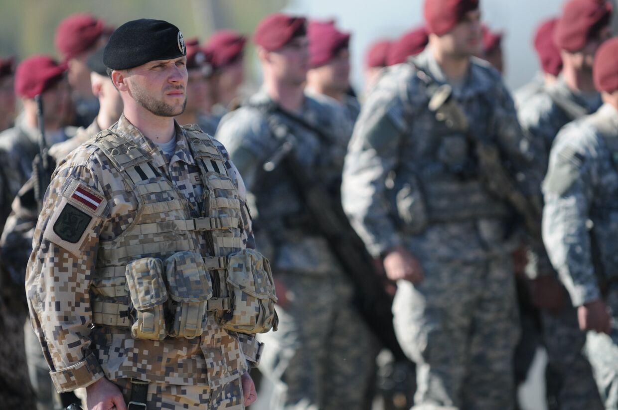 Латвийский и американский солдаты во время церемонии в Риге, посвященной началу совместных учений