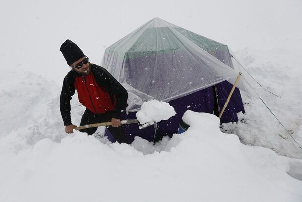 Альпинист из Германии расчищает походную кухню от снега